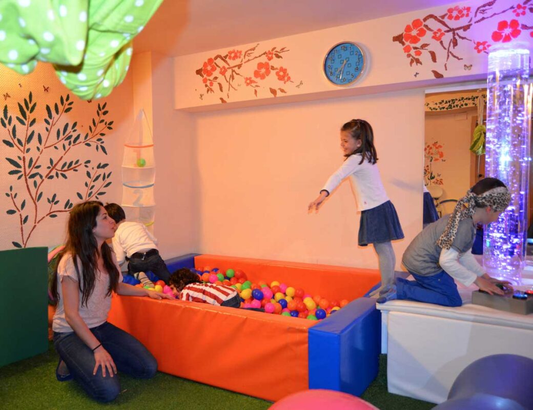 Niños juegan en una piscina de bolas con una terapeuta de Zubikoa