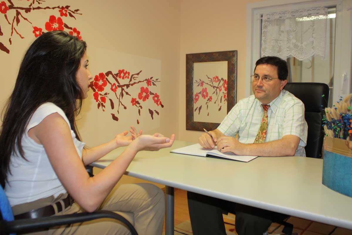 Una mujer y un hombre conversan en un despacho